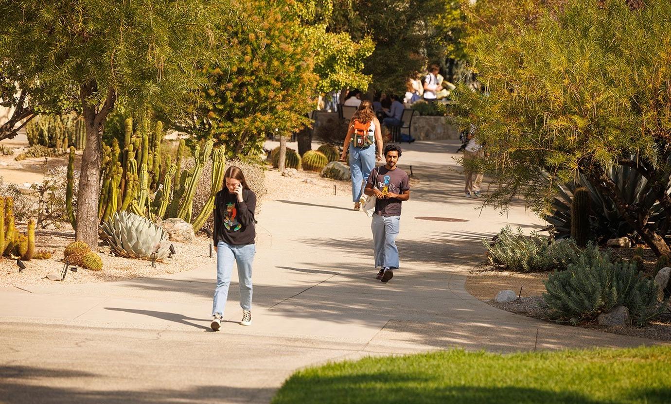 two students walk towards the mounds from scott courtyard